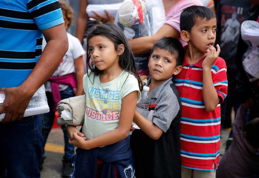 Immigrant children fleeing Central America arrive on government buses at the Central Station...