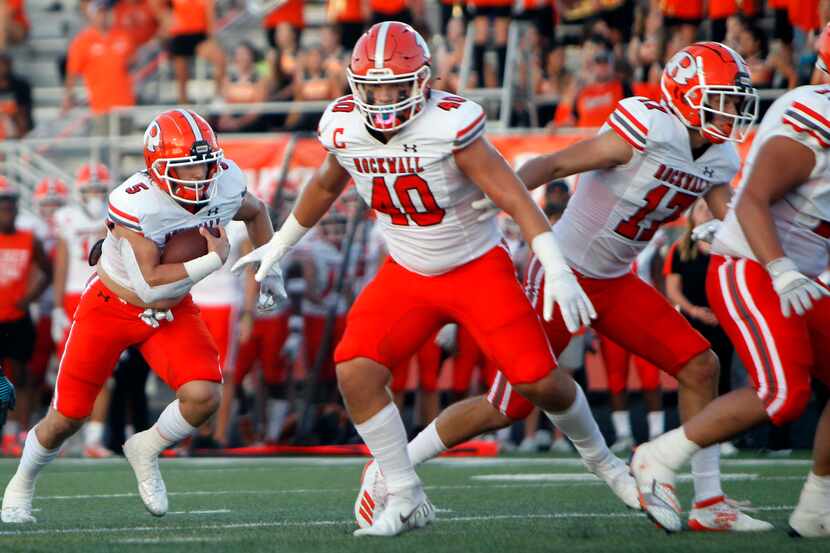 Rockwall quarterback Lake Bennett (5) follows his blockers into the end zone for a rushing...