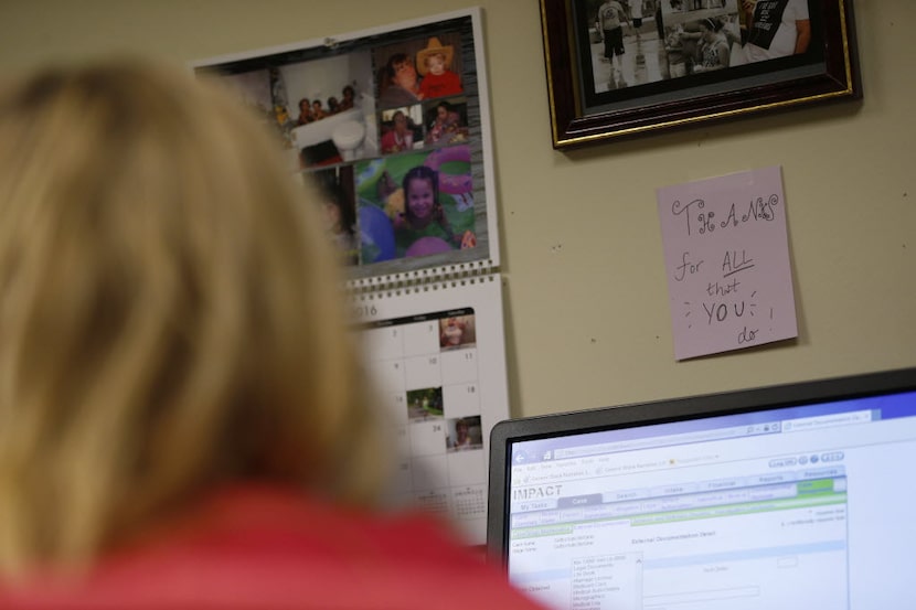 A motivational card on the wall and photos of her family hang in front of Tarrant County CPS...