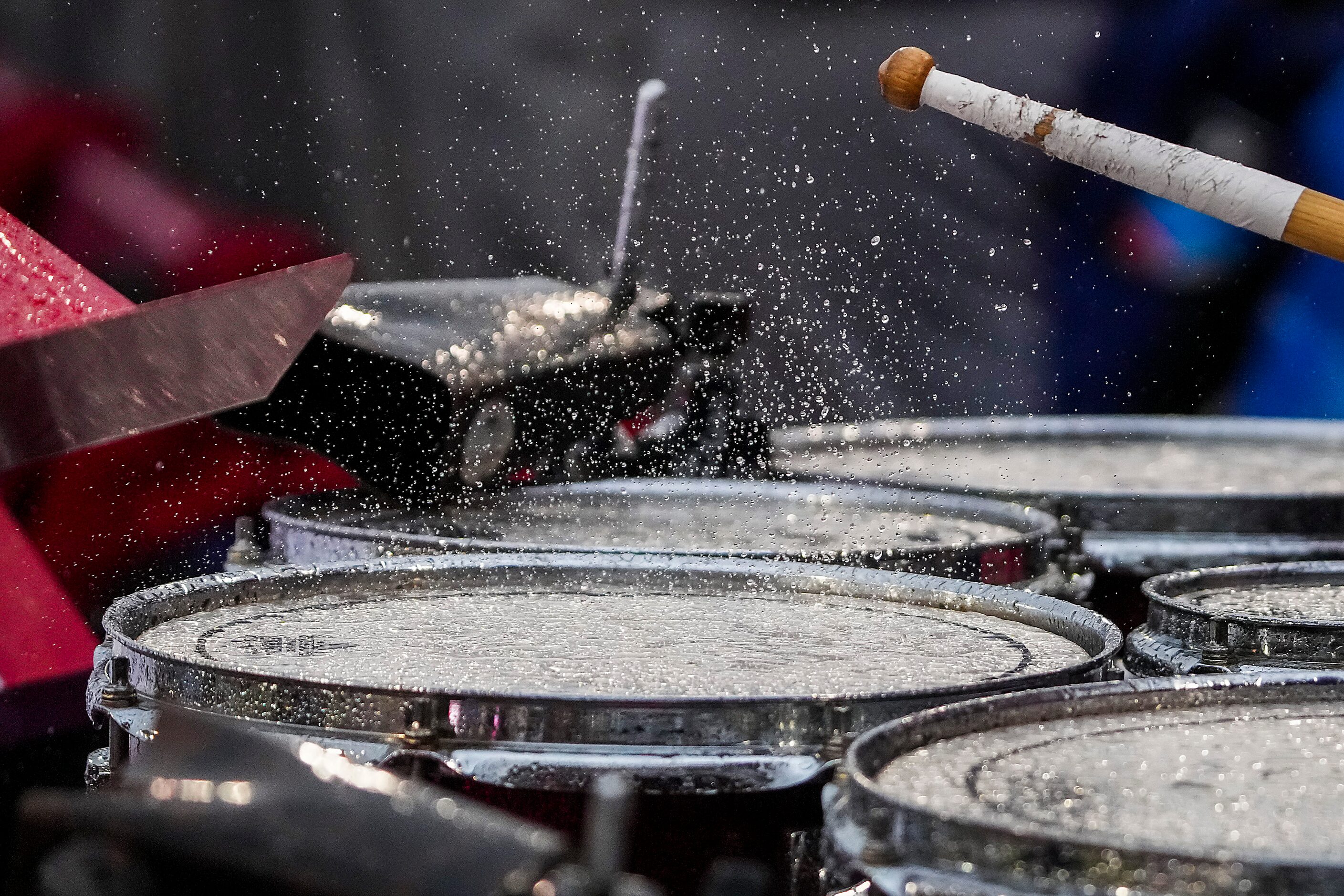 Rain splashed from a drum head as the SMU band plays during the first half of an NCAA...