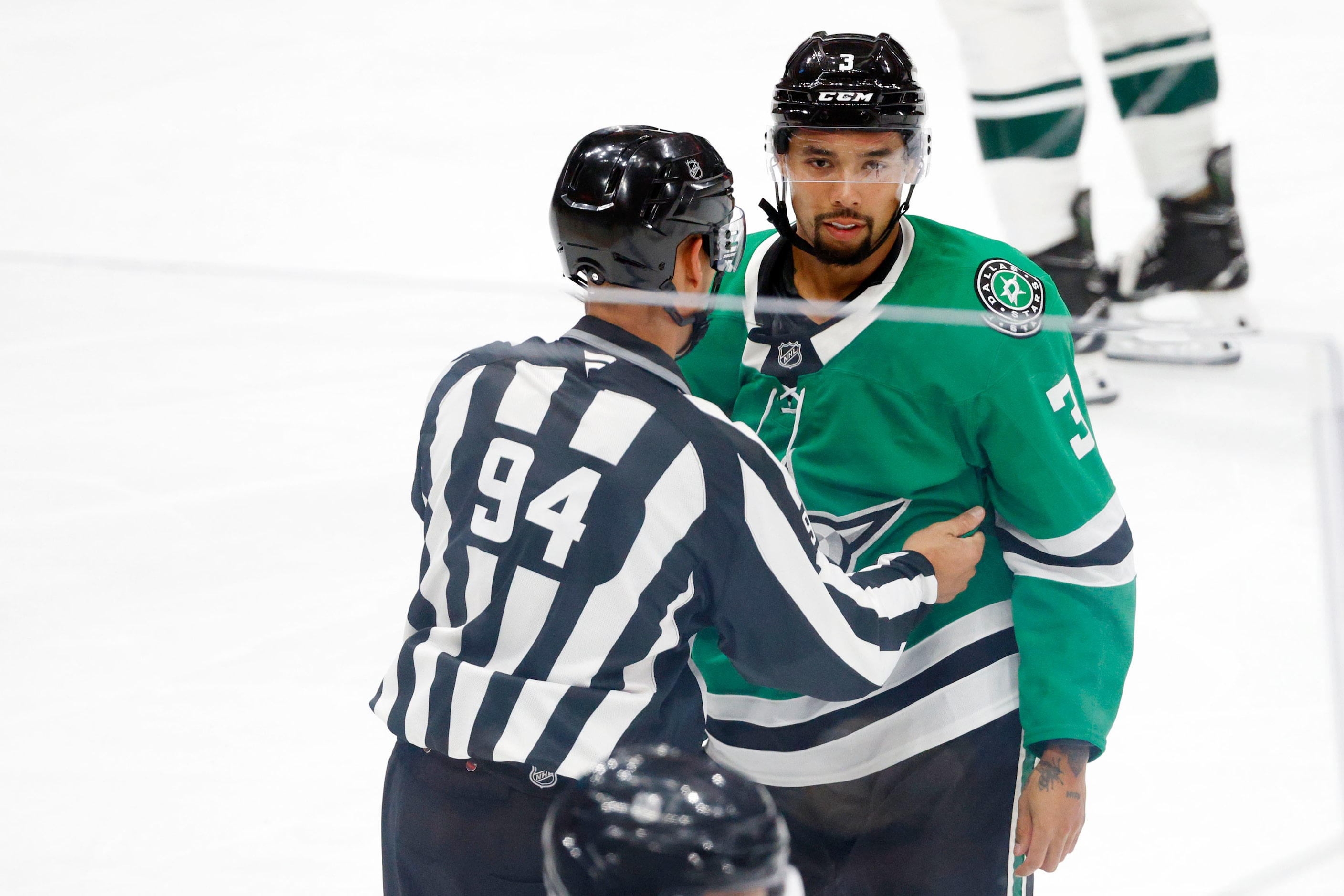 Linesman Bryan Pancich (94) holds Dallas Stars' Matt Dumba (3) back after a brief scuffle...