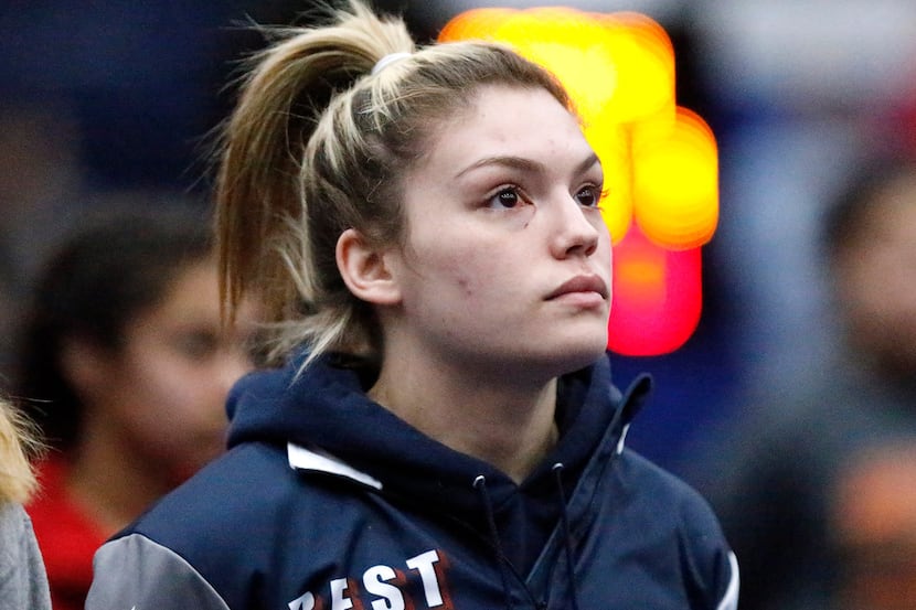 Allen High School wrestler Alex Liles eyes the U.S. flag during the national anthem at the...
