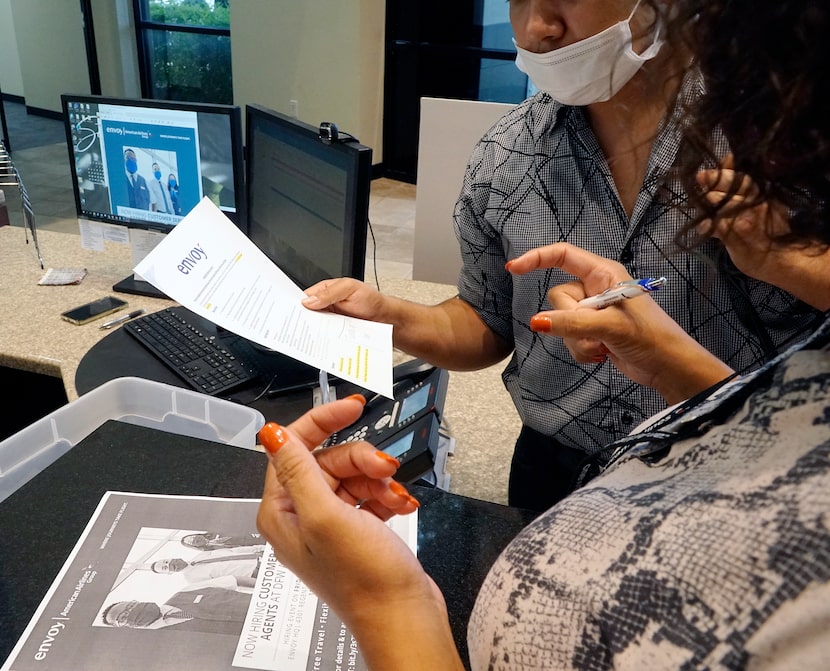 An applicant gets help applying for a job at Envoy Airlines in Irving during a recent job...