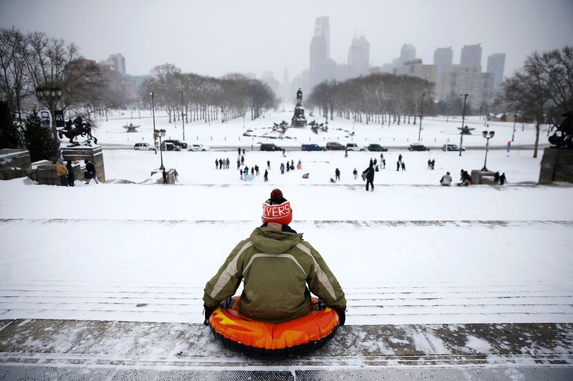  A man waits to sled down the steps of the Philadelphia Museum of Art during a snowstorm,...