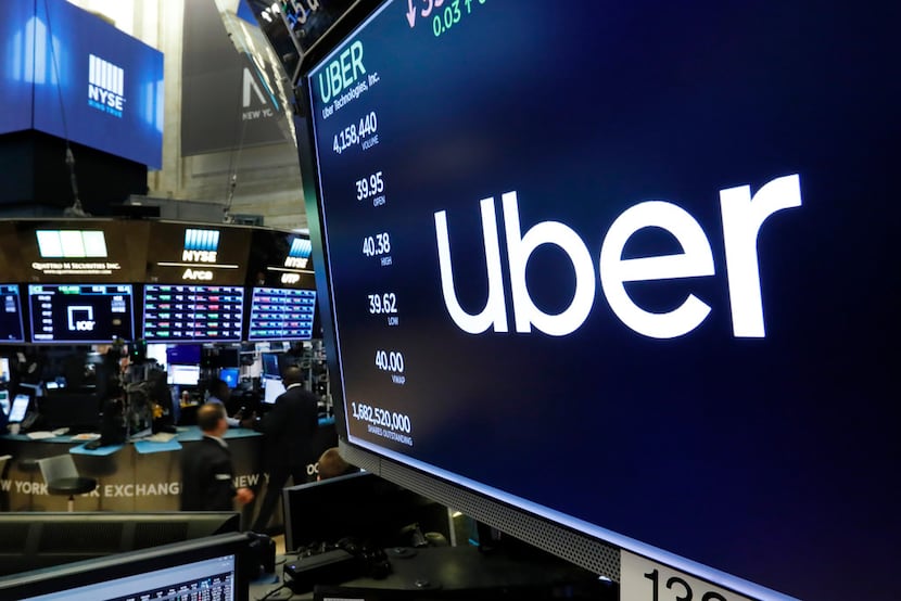  In this May 30, 2019, file photo the logo for Uber appears above a trading post on the...