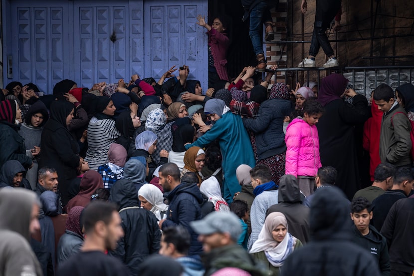 Palestinos tratan de comprar pan en una panadería en Rafah, en la Franja de Gaza, el domingo...