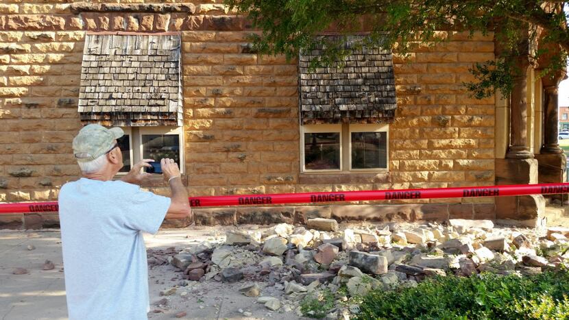 Steve Gibson of Pawnee takes photos of earthquake damage to a downtown building.