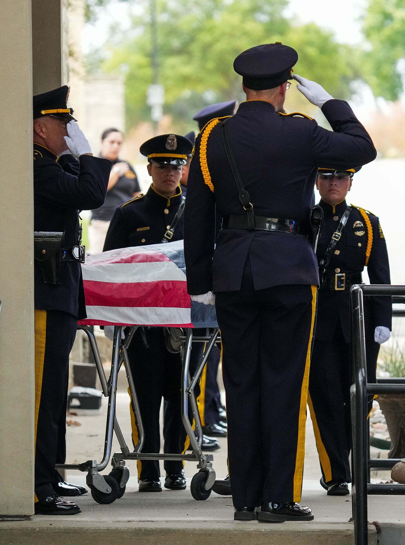 Members of the Dallas Police Honor Guard salute at Restland Funeral Home as fallen officer...