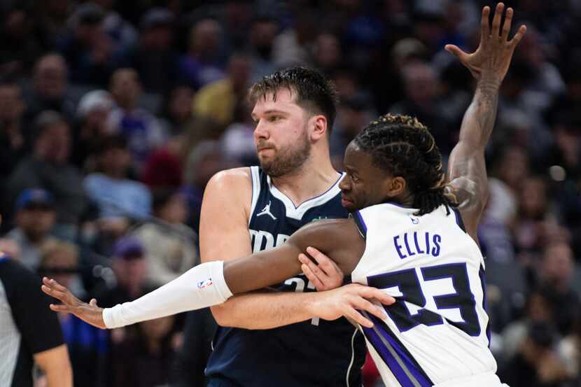 Sacramento Kings guard Keon Ellis (23) defends Dallas Mavericks guard Luka Doncic (77) in...
