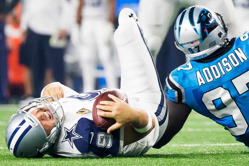 Dallas Cowboys quarterback Tony Romo (9) grimaces as he rests on the turf after being sacked...