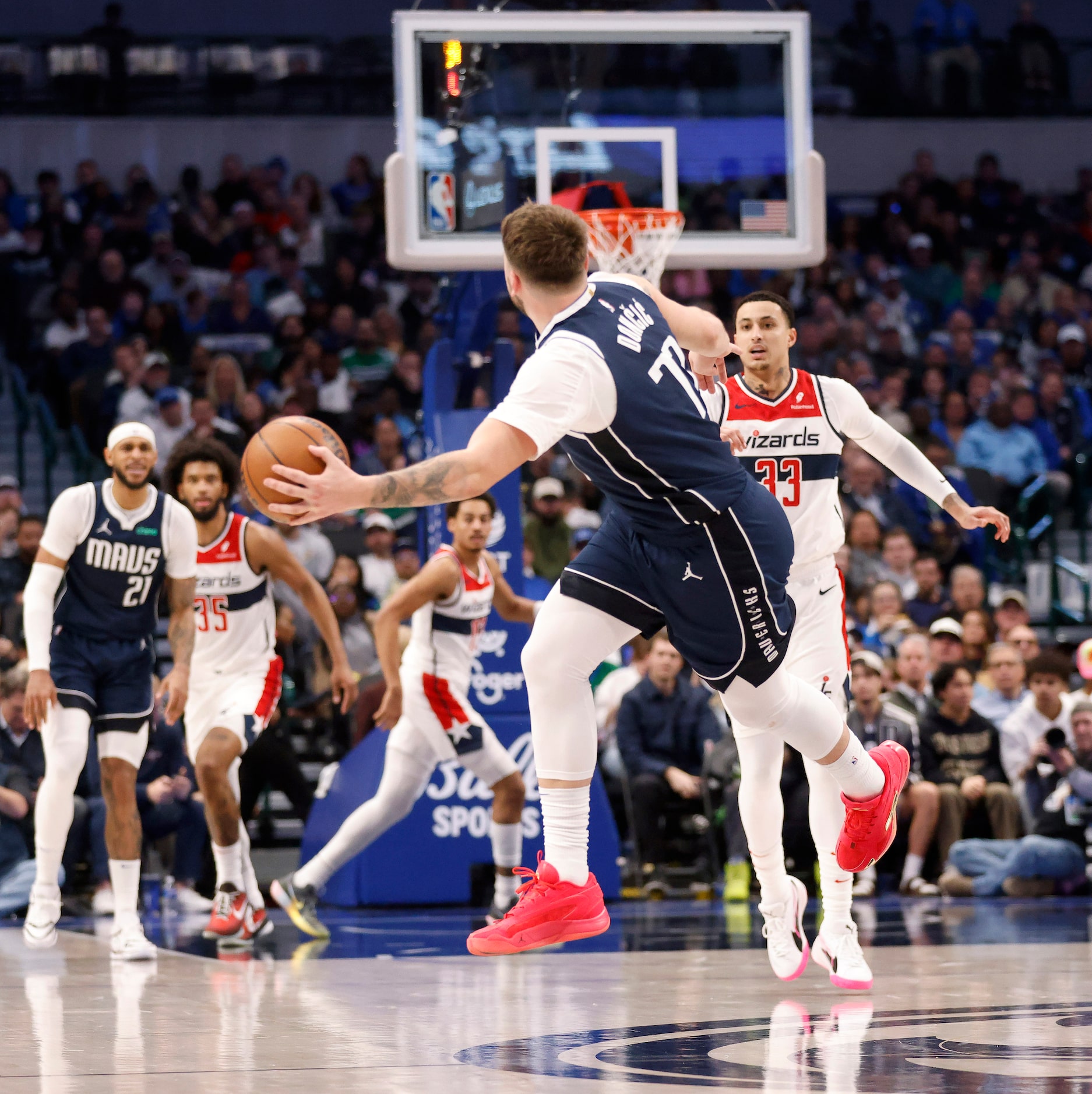 Dallas Mavericks guard Luka Doncic (77) tries to save the ball from going over the half...