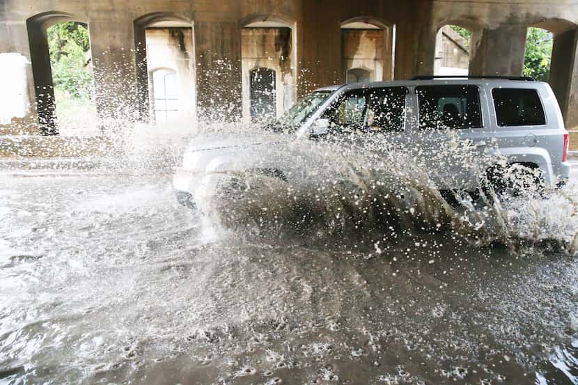 A car drives through standing water at 2400 Sylvan Ave.