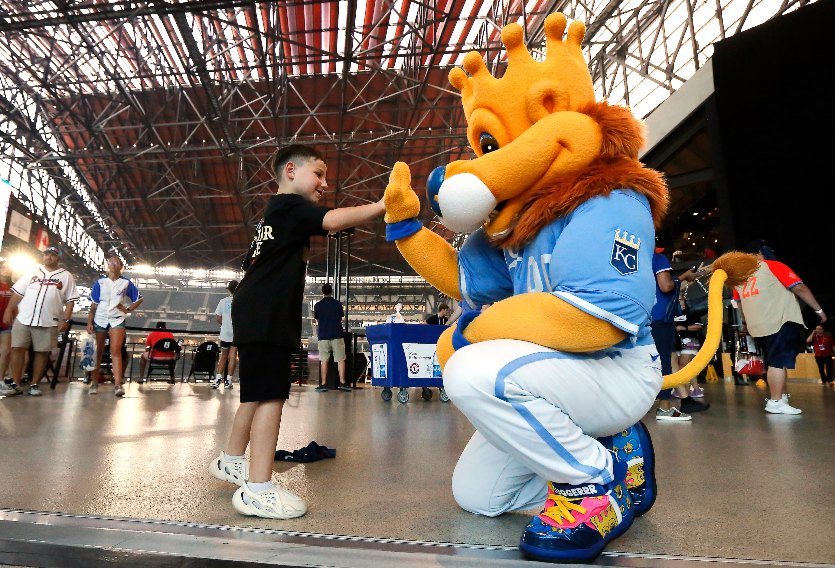 Elliot Cockerham 6, of Aubrey, Texas receives a high-five from Kansas City Royals mascot...