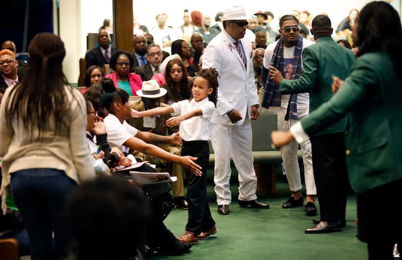 LaTiffiney Rodgers' 7 year-old son, Jorden, reaches for a cousin at a funeral service for...