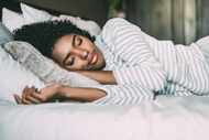 Close up of a woman with curly hair sleeping in bed