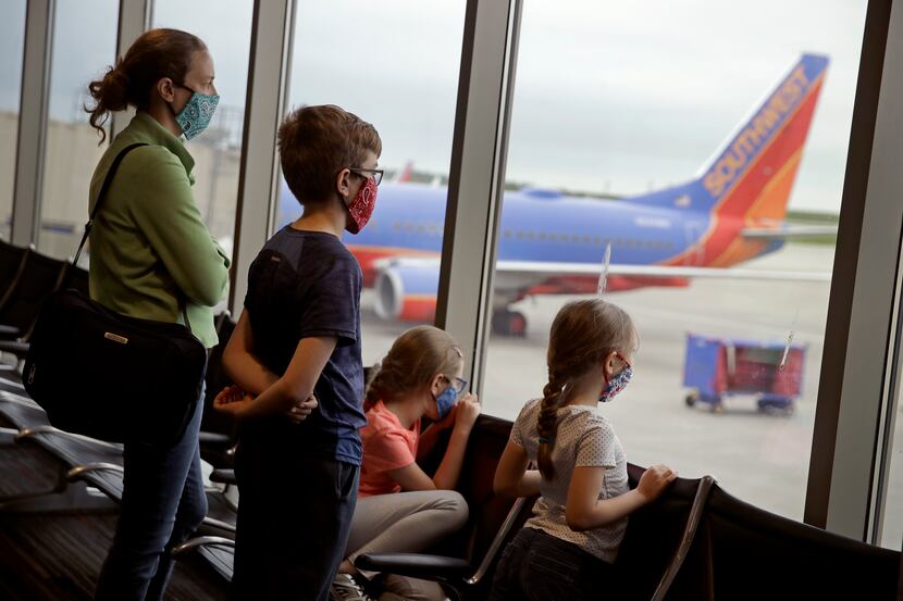 A family wearing masks waits to board a Southwest Airlines flight on May 24, 2020 at Kansas...