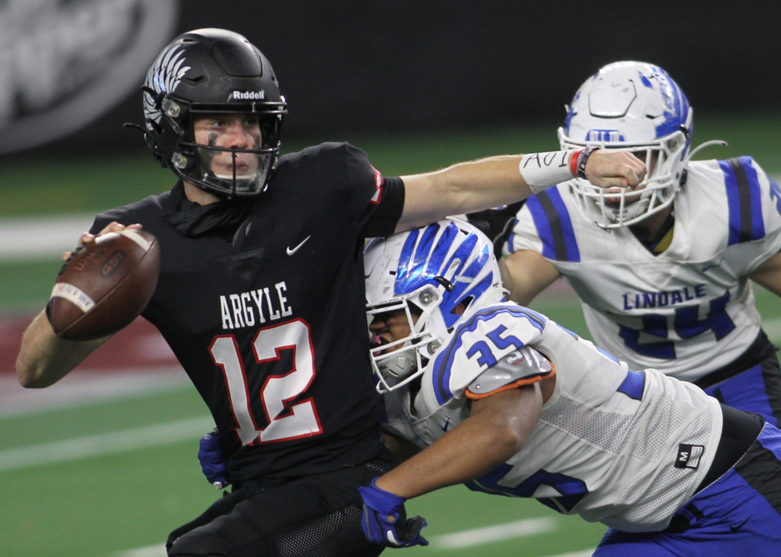 Argyle quarterback CJ Rogers (12) scrambles to elude the pursuit of Lindale defensive...