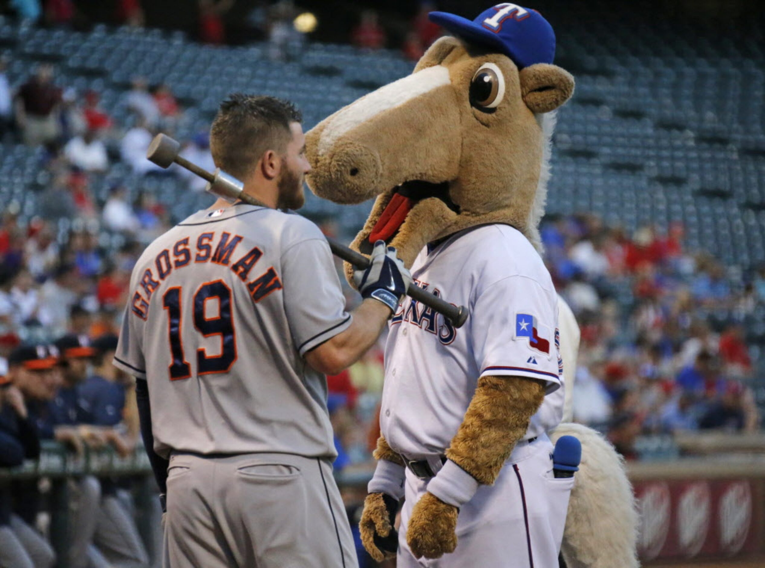 The Texas mascot "Rangers Captain" talks with Houston's Robbie Grossman before the start of...