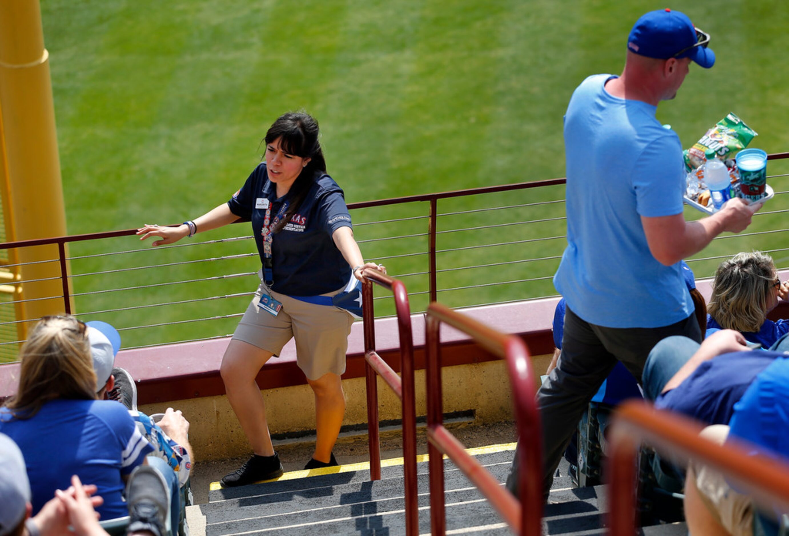 Texas Rangers usher Margarita Aguirre visits with fans between innings as she works in...