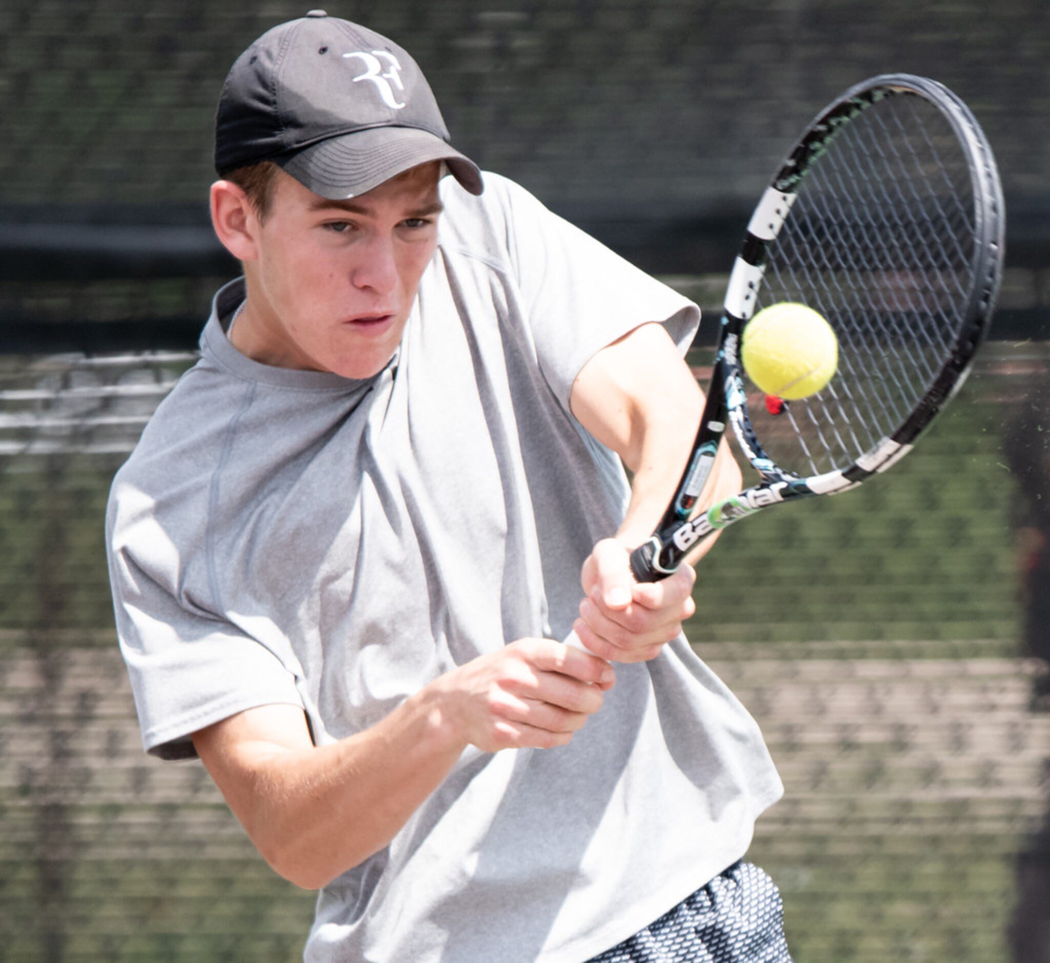 Southlake Carroll's Nick Ryniak returns the ball in a doubles match with teammate Gino...