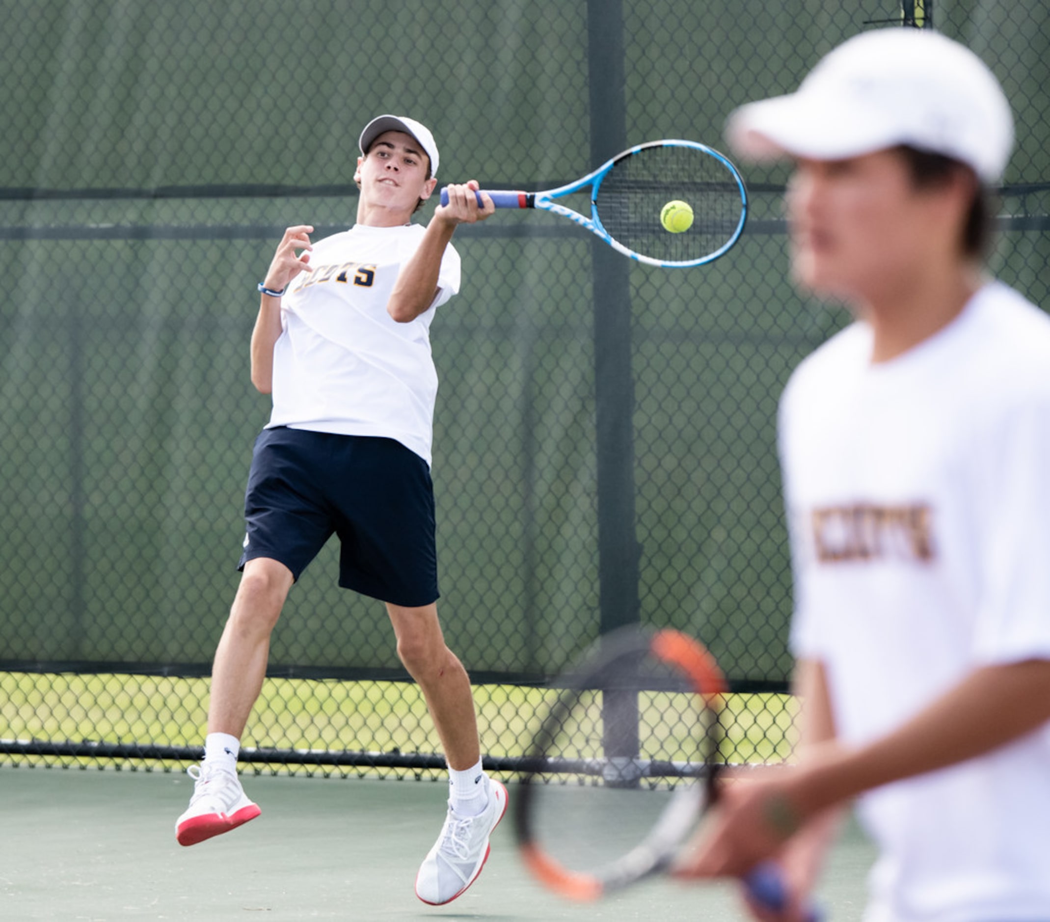 Highland Park's Ray Saalfield returns the ball in a doubles match with teammate Mikhail...