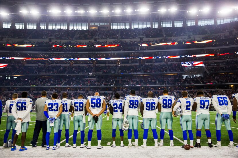 The Dallas Cowboys stand during the national anthem before their game against the Houston...