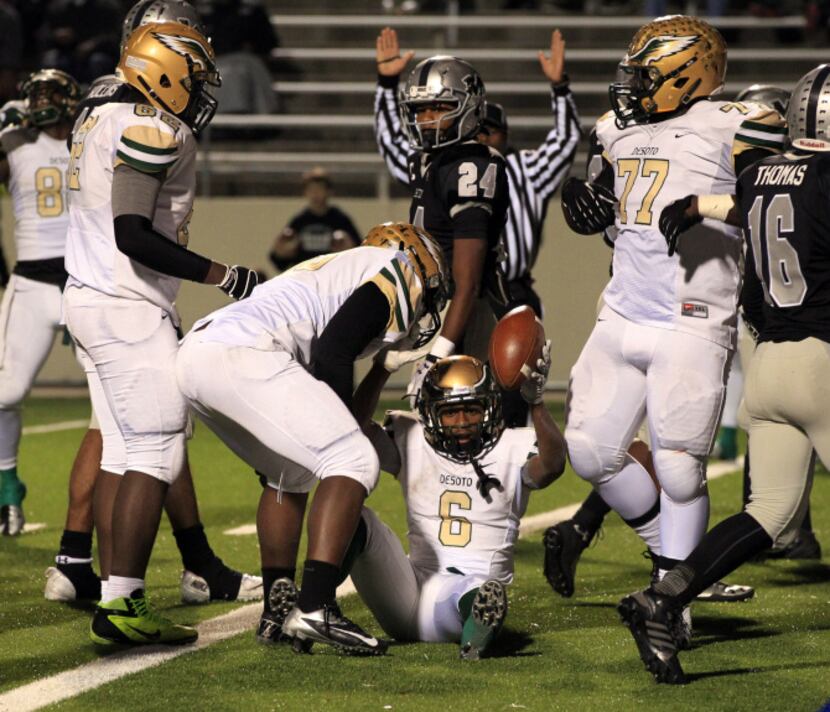 DeSoto High's Jaimon Peterson (6) holds the ball high after scoring a touchdown during the...