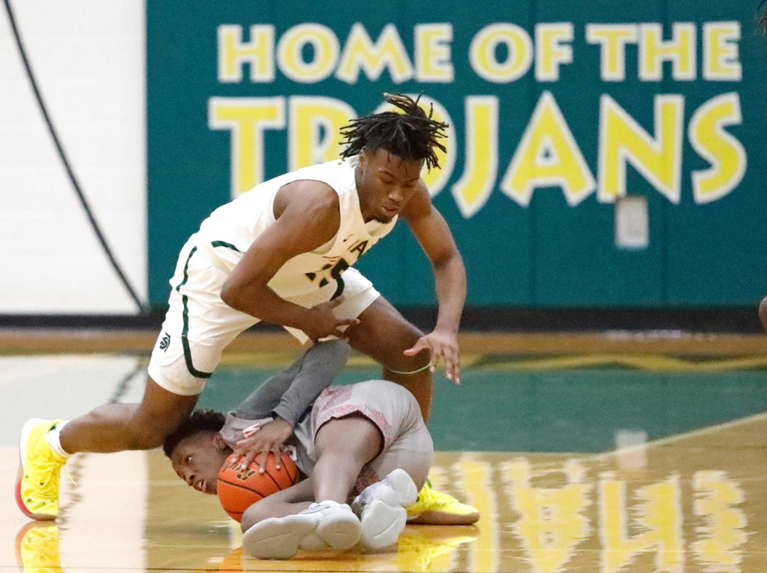 Newman Smith High School forward Domani Villaruel (25) falls onto Woodrow Wilson High School...