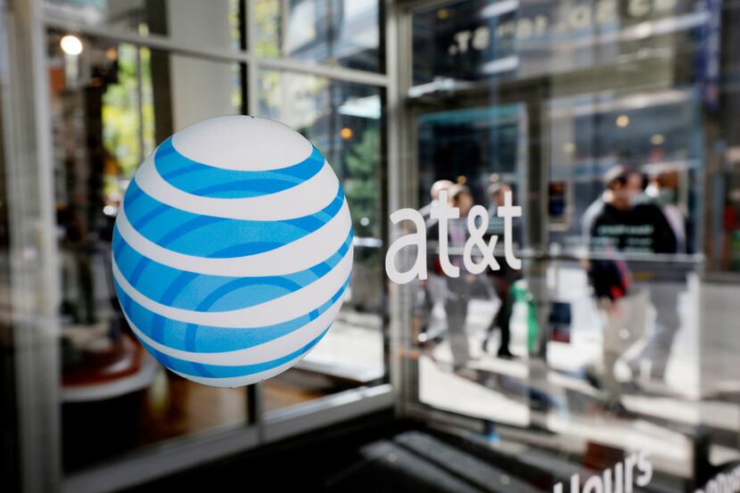 FILE - This Oct. 17, 2012, file photo shows an AT&T logo on an AT&T Wireless retail store...