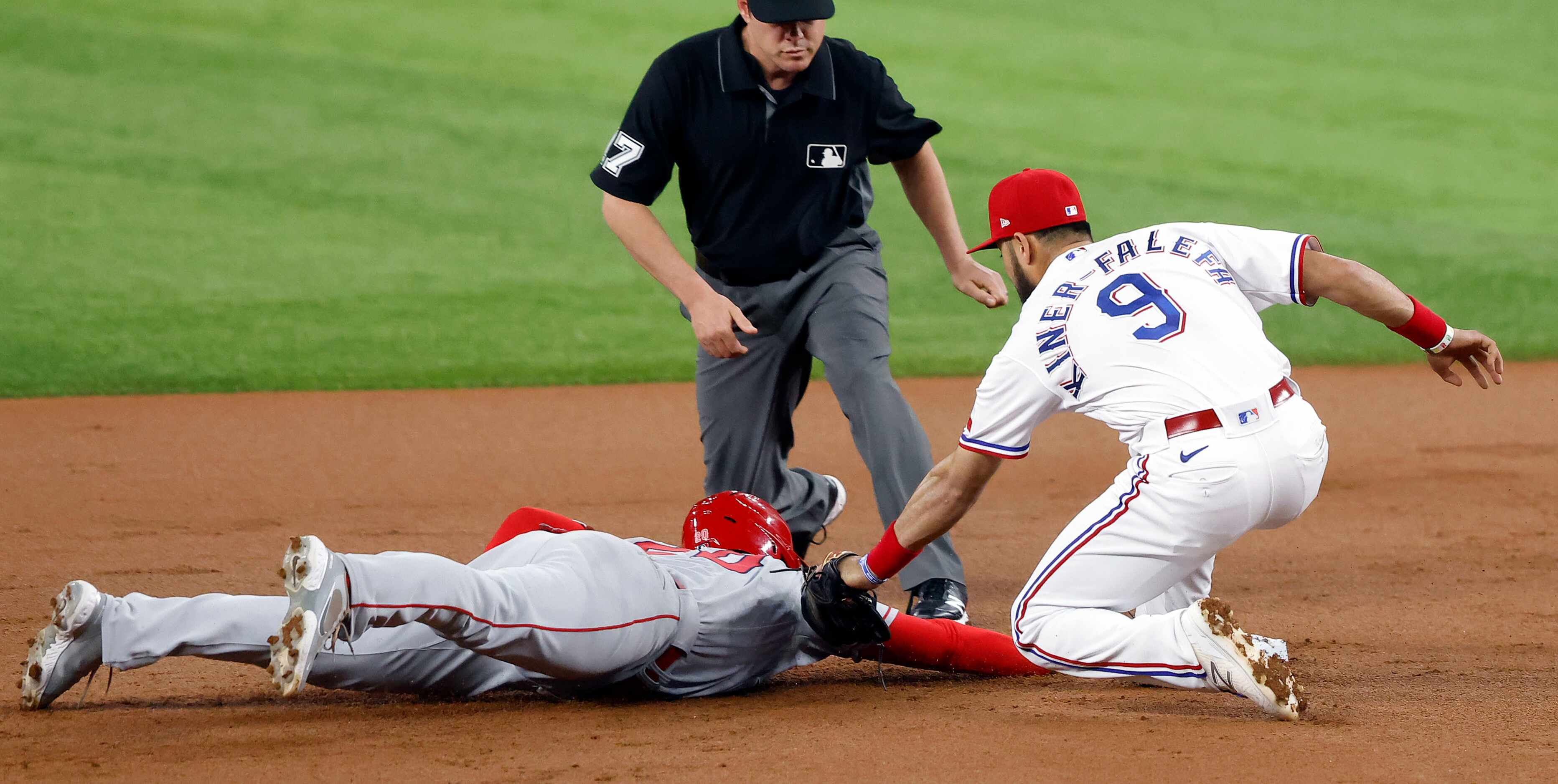 Los Angeles Angels Jared Walsh (20) dives back to second as Texas Rangers shortstop Isiah...