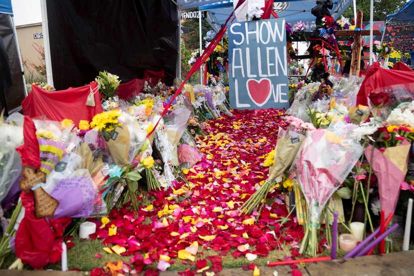 Flowers were left at a memorial setup honoring the victims of a mass shooting at the Allen...