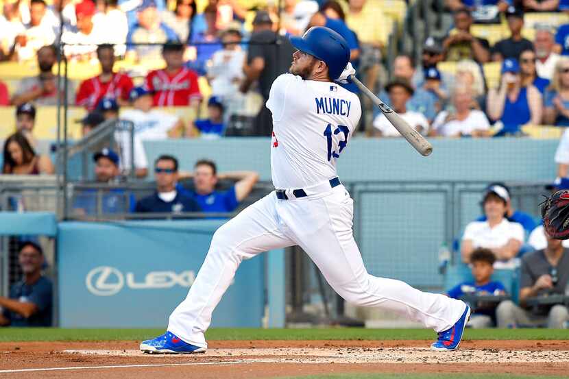 Los Angeles Dodgers' Max Muncy hits a solo home run during the first inning of a baseball...