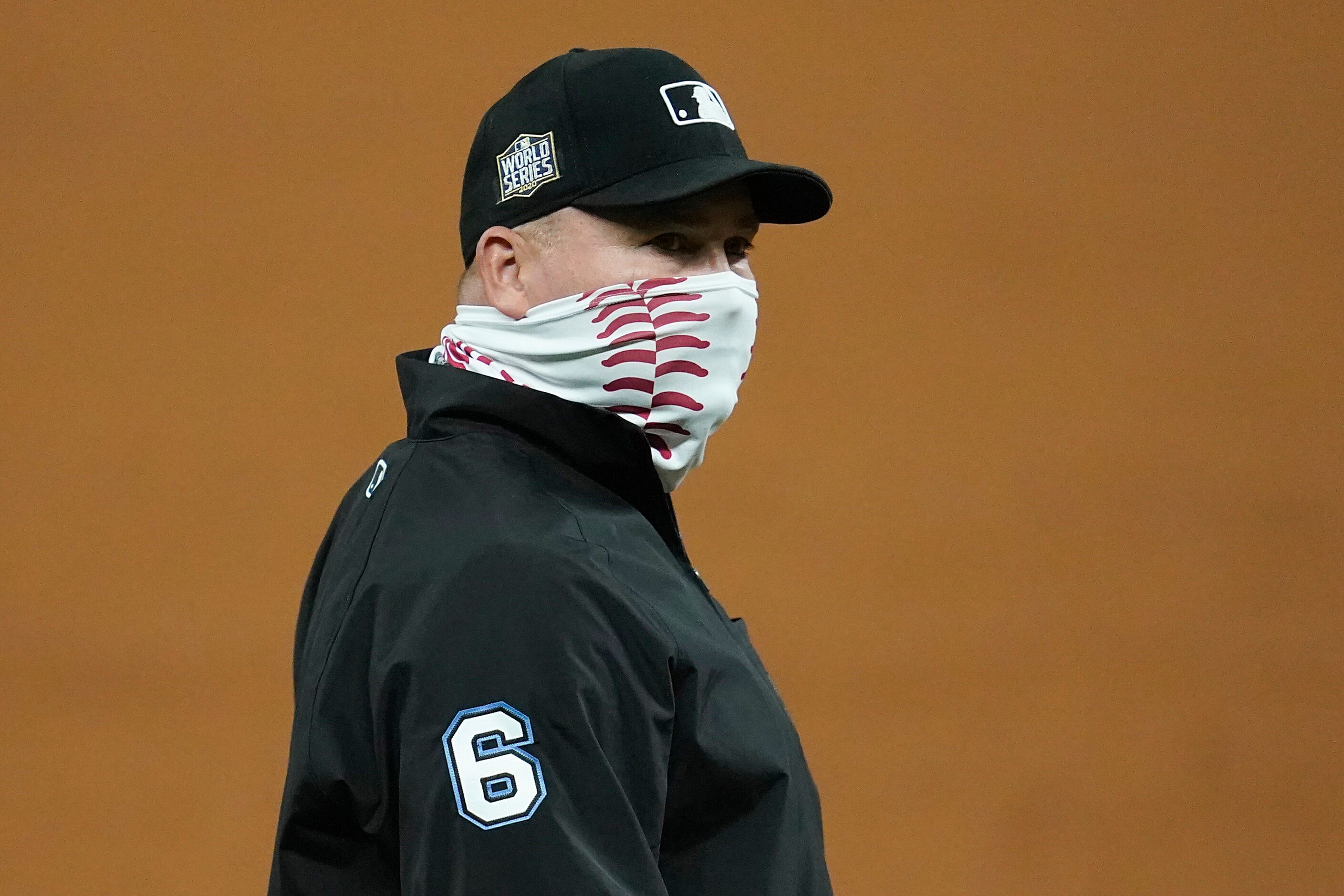 Umpire Mark Carlson wears a baseball themed face covering during the third inning in Game 3...