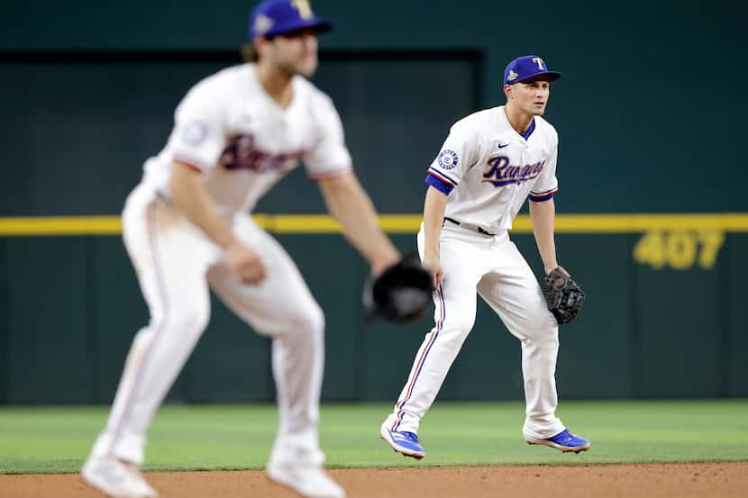 Texas Rangers shortstop Corey Seager (right) and shortstop Josh Smith (left) leap in unison...