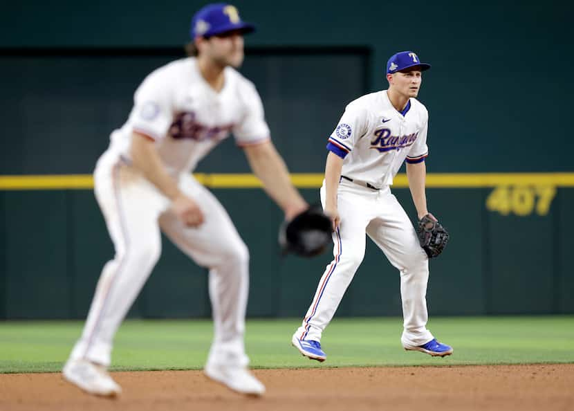 Texas Rangers shortstop Corey Seager (right) and shortstop Josh Smith (left) leap in unison...