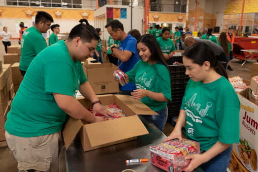 Un grupo de voluntarios junta alimentos para el North Texas Food Bank que participará en la...