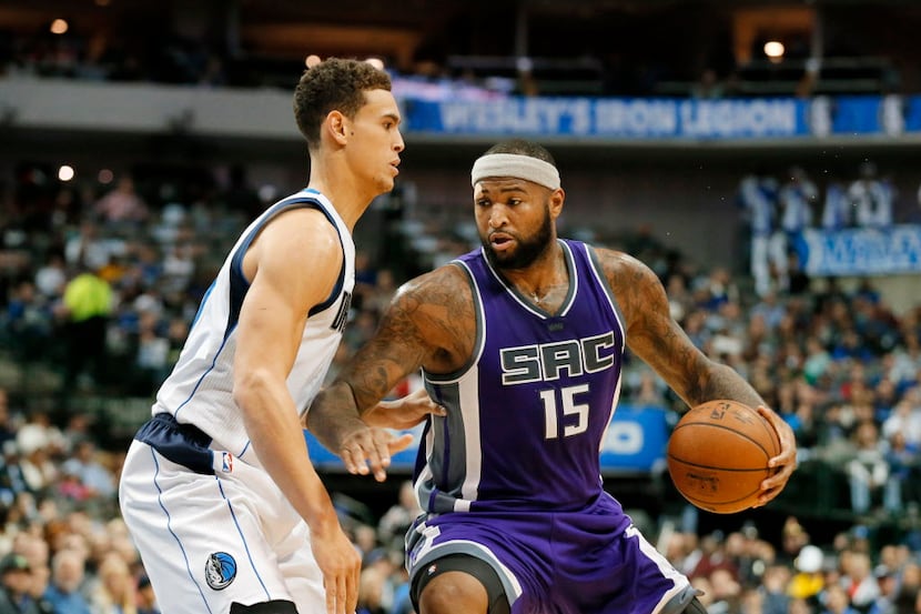 Dallas Mavericks' Dwight Powell, left, defends as Sacramento Kings' DeMarcus Cousins (15)...