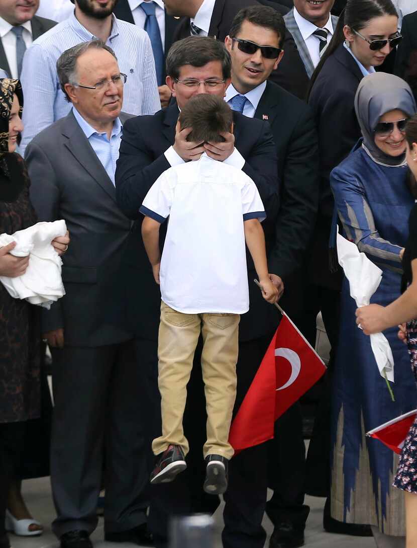  Turkeys Prime minister Ahmet Davutoglu (C) kisses a boy of a hostage as he welcomes on...