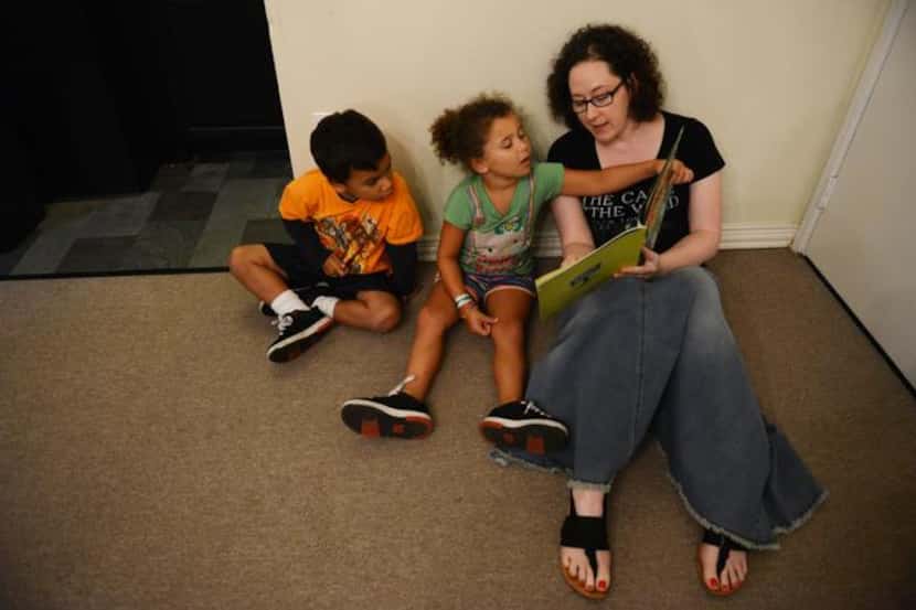
Volunteer Larel Bender reads a book to Da'Marcus Robinson, 3, and Mikayla Hubbard, 5, at...