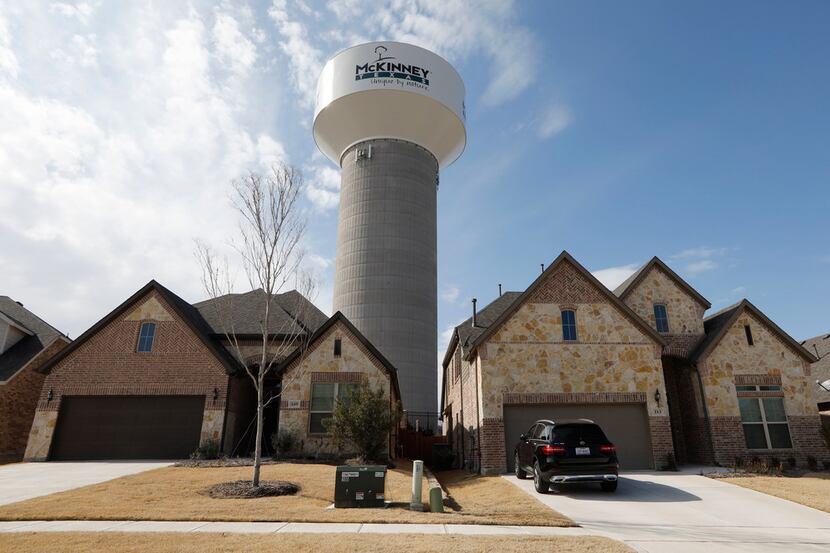 A McKinney water tower looms behind new homes in the 100 block of Leadville Way in McKinney...