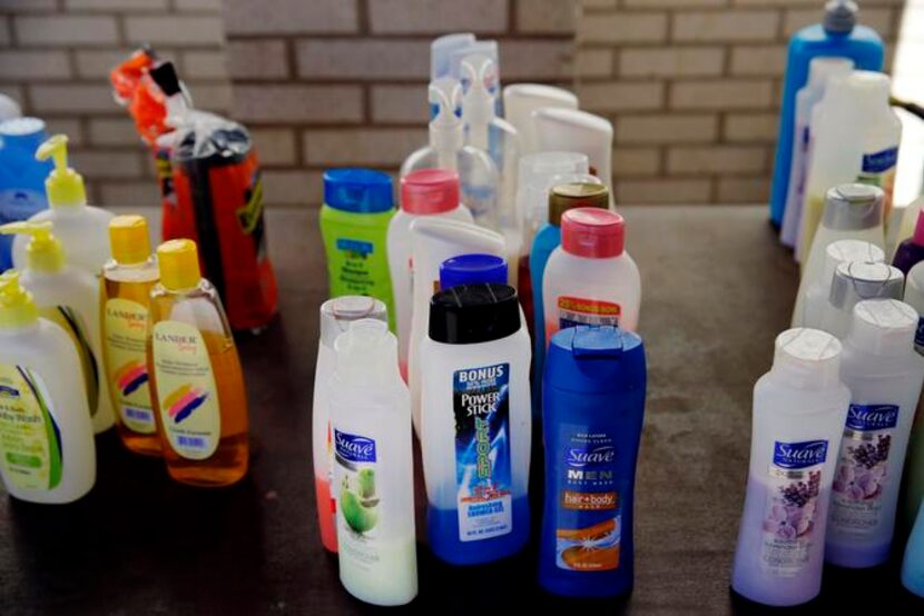 
Bathing products line a table by portable showers at Sacred Heart Catholic Church...