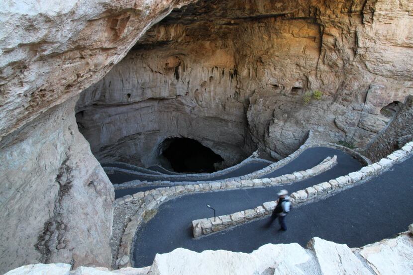 A visitor walks down the natural entrance at Carlsbad Caverns National Park near Carlsbad,...