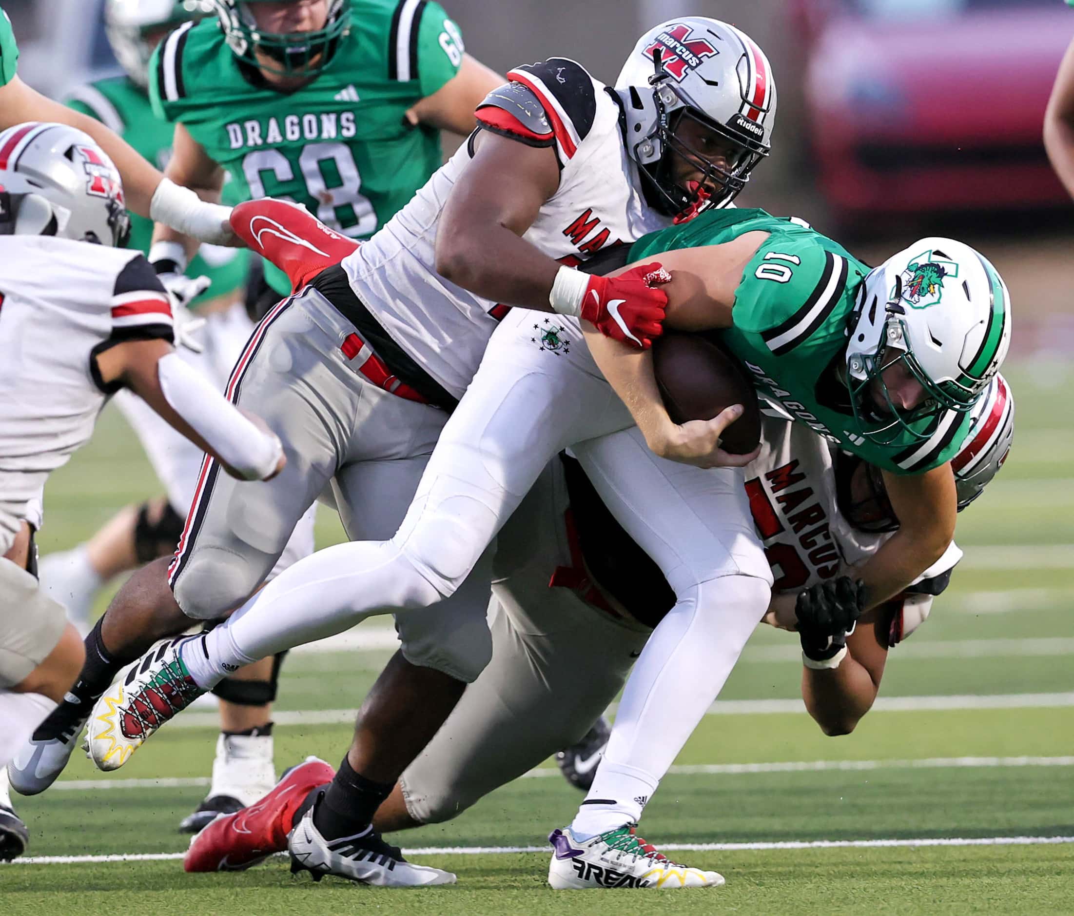 Southlake Carroll quarterback Graham Knowles (10) gets pulled down for a short gain by...