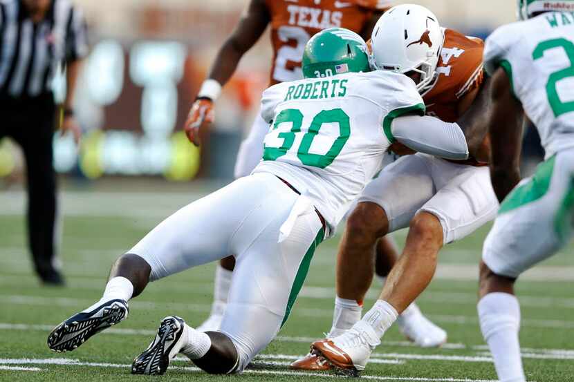 Texas Longhorns quarterback David Ash (14) is hit by North Texas Mean Green defensive end...