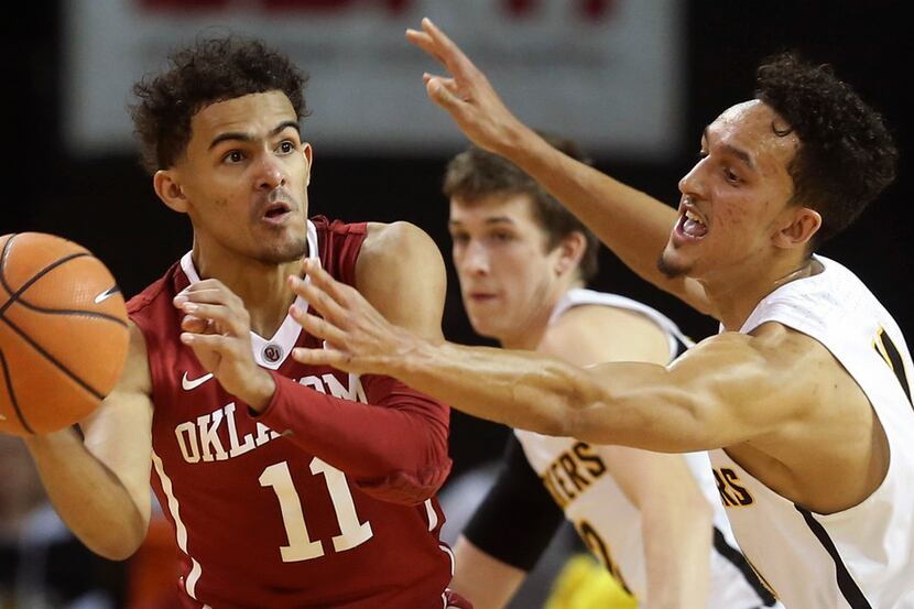 Oklahoma guard Trae Young, left, looks to pass as he's defended by Wichita State guard...