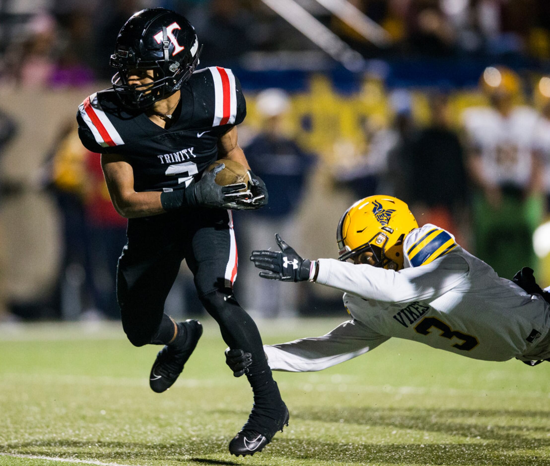 Euless Trinity running back Zechariah Moore (3) avoids a tackle attempt by Arlington Lamar...