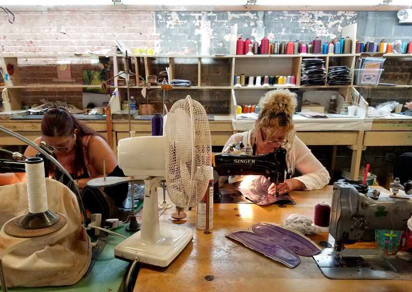 Using vintage Singer sewing machines, workers stitch patterns on boot leather at M.L....