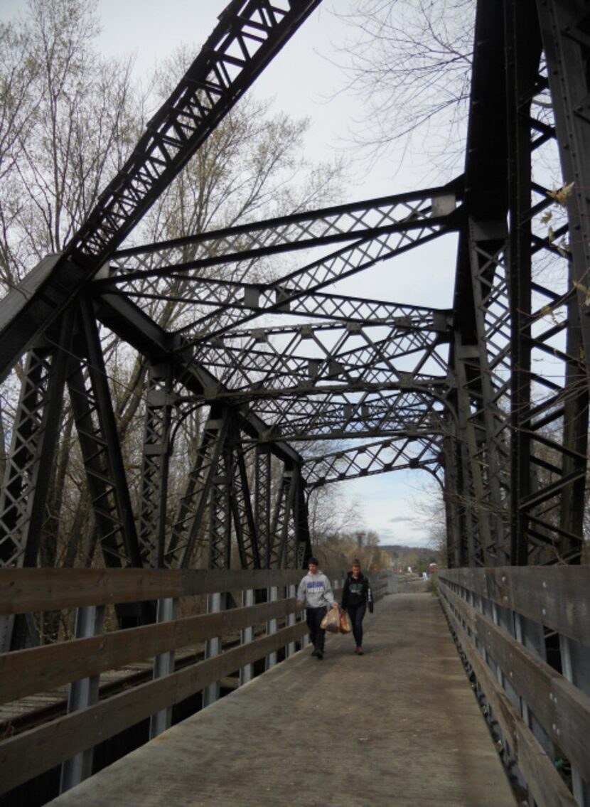 Walkers cross a retired railroad bridge along the Hockhocking Adena Trail, where trains once...