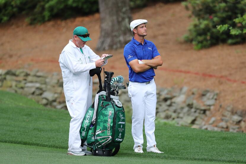 AUGUSTA, GEORGIA - APRIL 14: Bryson DeChambeau of the United States stands with caddie Tim...
