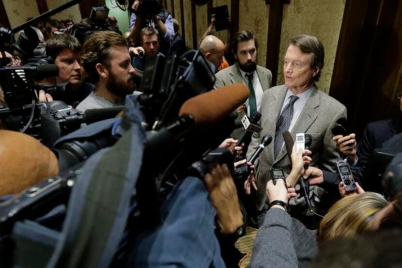 
University of Texas at Austin President Bill Powers, center, talks with the media following...